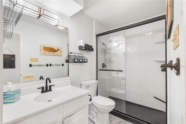 bathroom featuring a textured ceiling, vanity, toilet, and a shower with shower door