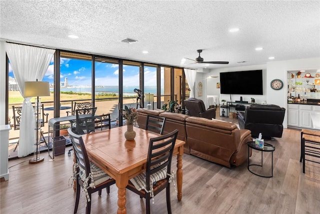1400 Ocean Dr Unit 304C, Corpus Christi, TX 78404 - dining area with a textured ceiling, a wall of windows, ceiling fan, light wood finished floors, and recessed lighting