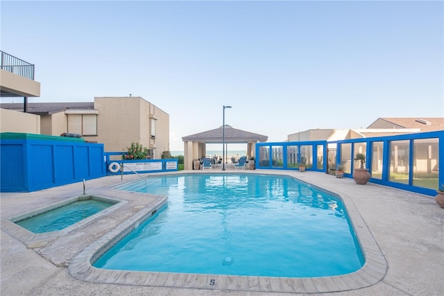 view of pool with a gazebo, a community hot tub, and a patio