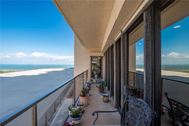 balcony featuring a water view and a view of the beach