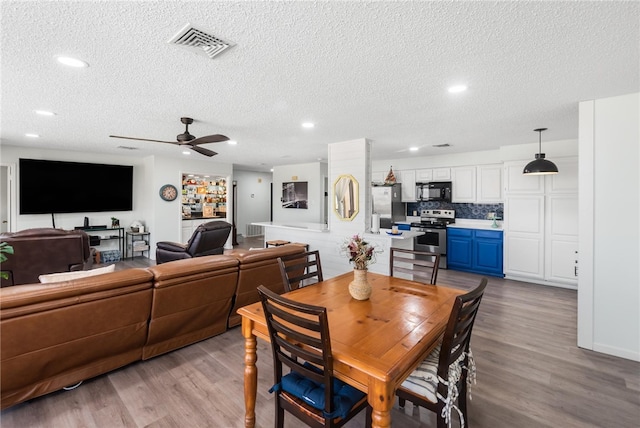 dining room with ceiling fan, light hardwood / wood-style floors, and a textured ceiling