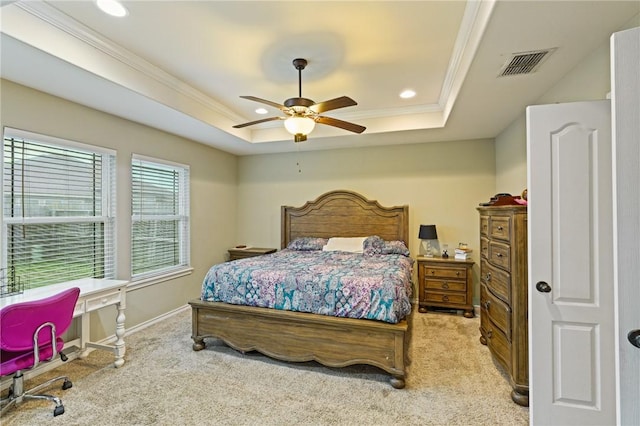 carpeted bedroom with a tray ceiling, recessed lighting, visible vents, and crown molding