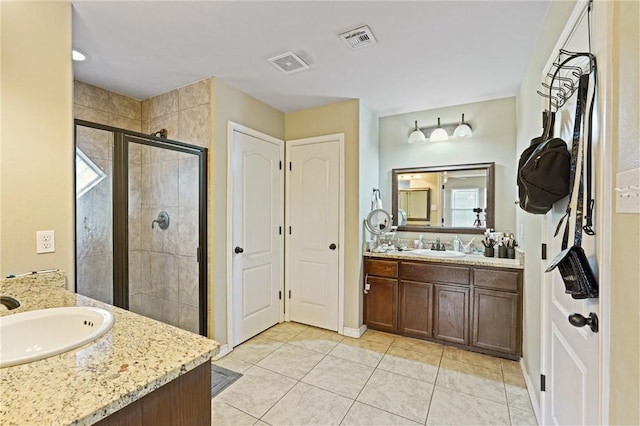 full bath with a stall shower, two vanities, a sink, and visible vents