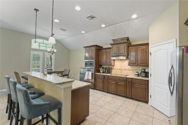 kitchen featuring stainless steel appliances, visible vents, backsplash, vaulted ceiling, and under cabinet range hood