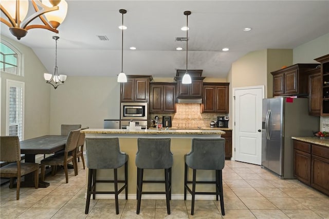 kitchen with a breakfast bar area, dark brown cabinetry, stainless steel appliances, visible vents, and vaulted ceiling