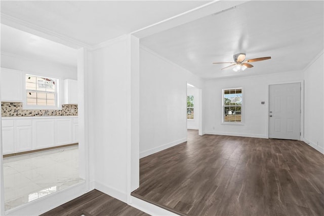 1113 Annapolis Dr, Corpus Christi, TX 78404 - unfurnished living room featuring dark wood-style floors, ceiling fan, crown molding, and baseboards