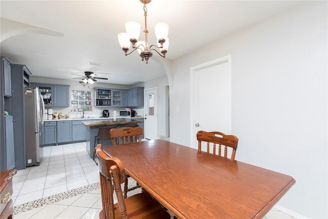 1124 Orange St, Mercedes, TX 78570 - dining room featuring arched walkways, a chandelier, light tile patterned floors, and ceiling fan