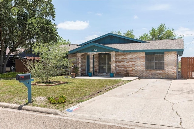 1124 Orange St, Mercedes, TX 78570 - view of front of home featuring brick siding, roof with shingles, and covered porch