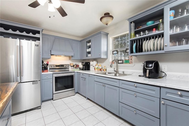 1124 Orange St, Mercedes, TX 78570 - kitchen featuring stainless steel appliances, a sink, custom exhaust hood, and gray cabinetry