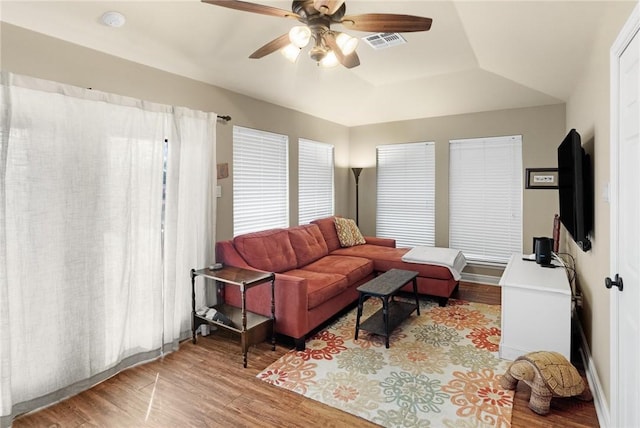 living area featuring a ceiling fan, visible vents, and wood finished floors