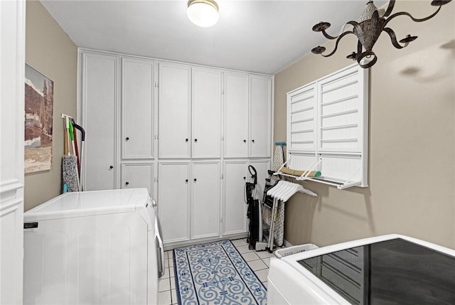 washroom featuring cabinet space, light tile patterned floors, and separate washer and dryer