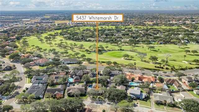 drone / aerial view featuring view of golf course and a residential view