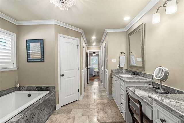 ensuite bathroom with ornamental molding, vanity, baseboards, and a bath