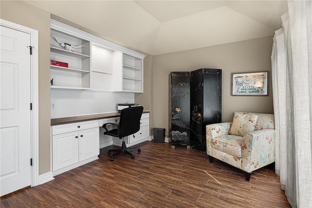 office area featuring dark wood-type flooring, lofted ceiling, and built in desk