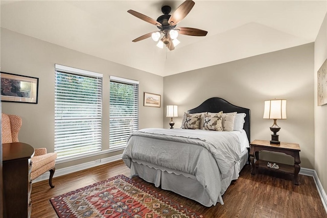 bedroom featuring ceiling fan, dark wood finished floors, lofted ceiling, and baseboards