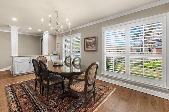 dining space featuring ornamental molding, decorative columns, light wood-style flooring, and baseboards