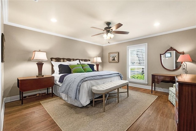 bedroom featuring baseboards, wood finished floors, and crown molding