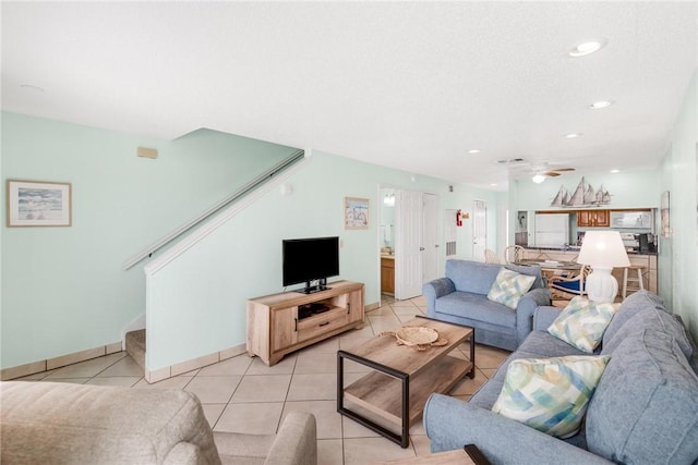 living area featuring recessed lighting, a ceiling fan, light tile patterned flooring, baseboards, and stairs