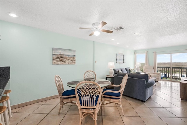 dining area featuring light tile patterned floors, ceiling fan, visible vents, and baseboards