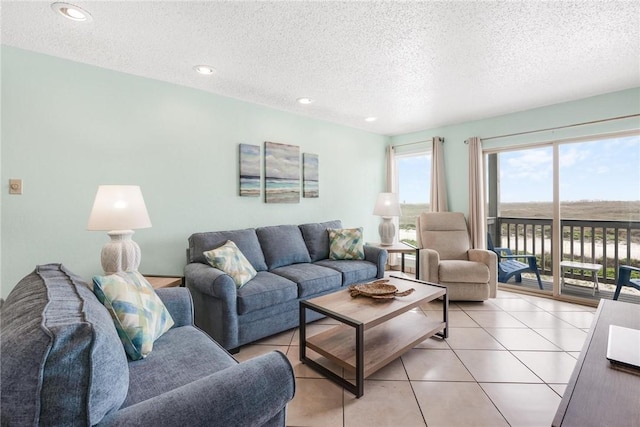 living area featuring light tile patterned floors, a textured ceiling, and recessed lighting