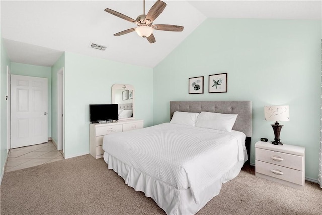 bedroom with light tile patterned floors, visible vents, light colored carpet, ceiling fan, and vaulted ceiling