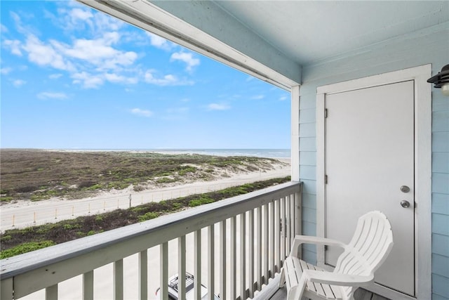 balcony featuring a water view and a beach view