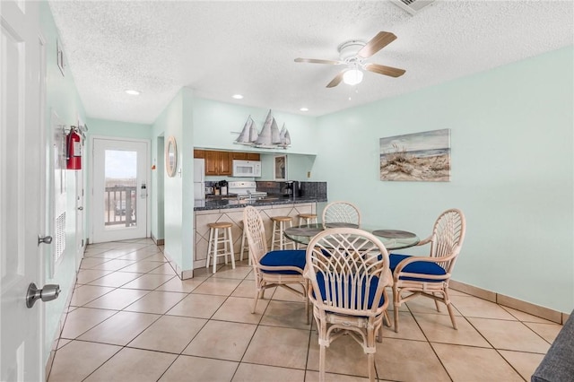 dining area featuring light tile patterned floors, baseboards, ceiling fan, a textured ceiling, and recessed lighting