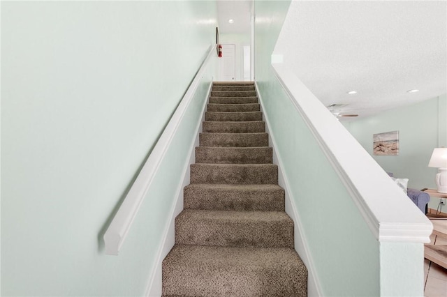 stairway featuring a ceiling fan and recessed lighting