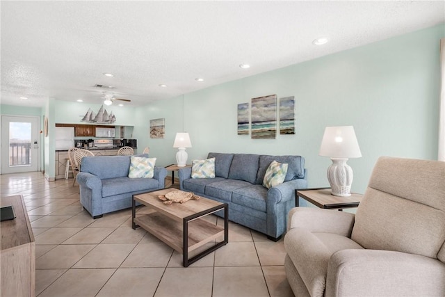 living room with light tile patterned floors, a textured ceiling, a ceiling fan, and recessed lighting