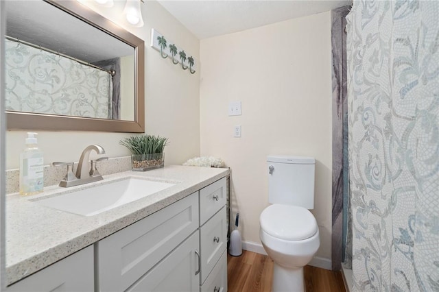 full bath featuring baseboards, toilet, wood finished floors, and vanity