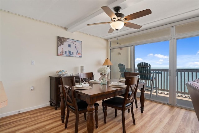 dining room with a ceiling fan, beamed ceiling, light wood-style floors, and baseboards