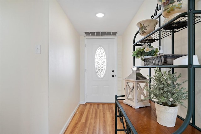 doorway featuring visible vents, baseboards, and wood finished floors