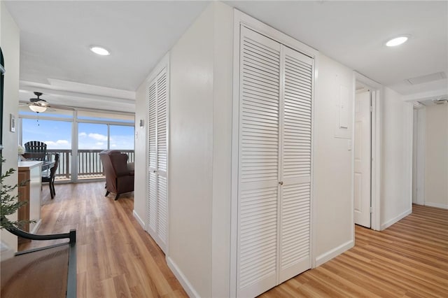 hallway featuring recessed lighting, baseboards, and light wood-type flooring