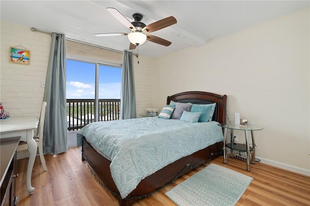 bedroom featuring beamed ceiling, a ceiling fan, access to outside, wood finished floors, and baseboards