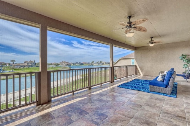 view of patio / terrace featuring a water view, ceiling fan, and a balcony