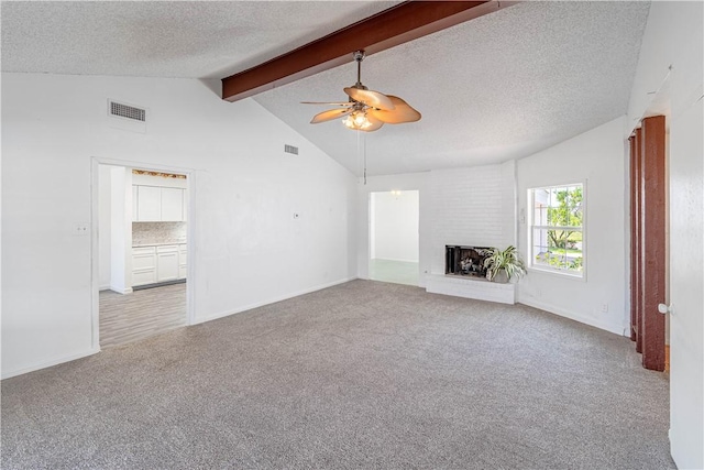 2406 Lakeview Dr, Rockport, TX 78382 - unfurnished living room with carpet, a ceiling fan, a textured ceiling, and a brick fireplace