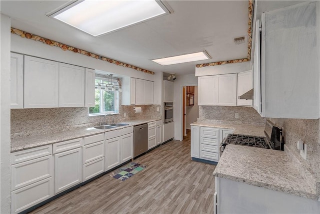 2406 Lakeview Dr, Rockport, TX 78382 - kitchen with stainless steel appliances, backsplash, white cabinetry, and light countertops