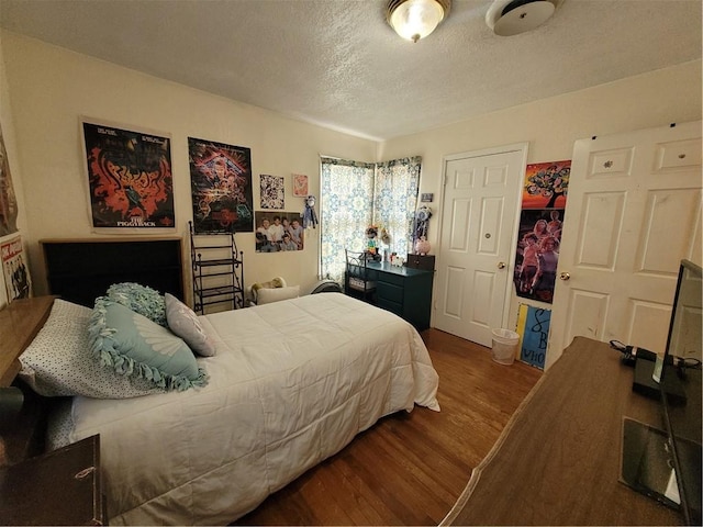 bedroom with hardwood / wood-style floors and a textured ceiling