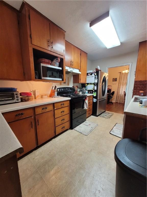 kitchen with stainless steel fridge and black range with electric cooktop