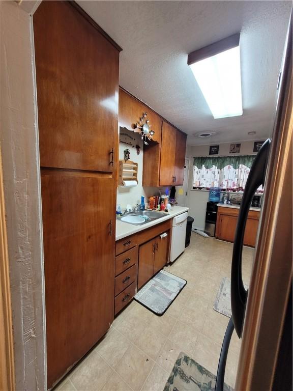 kitchen featuring white dishwasher and sink