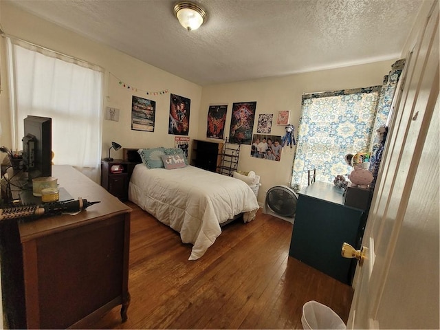 bedroom with dark wood-type flooring and a textured ceiling