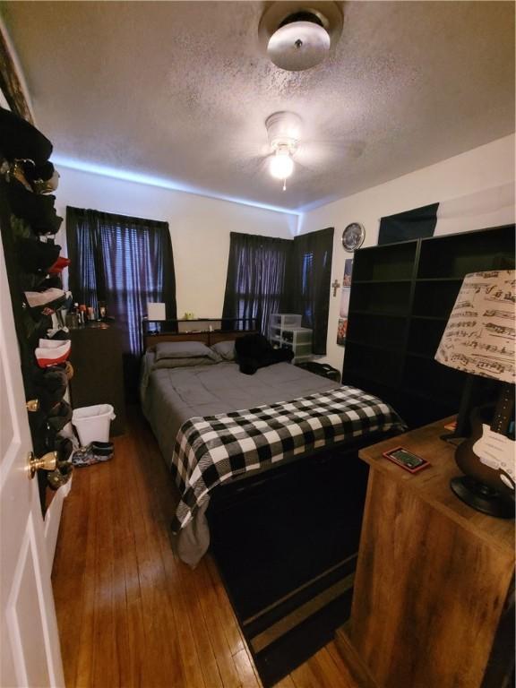 bedroom featuring hardwood / wood-style flooring and a textured ceiling