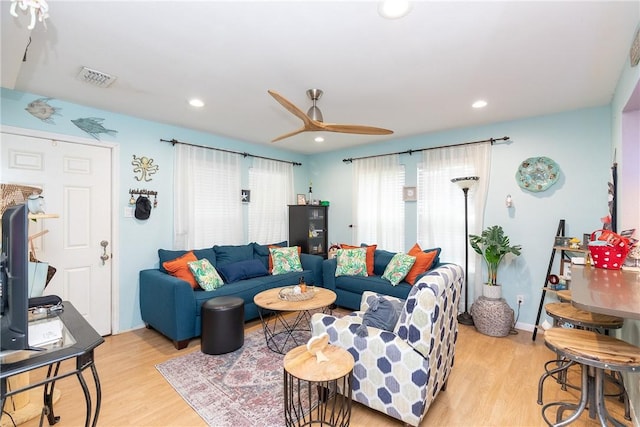 living room featuring ceiling fan and light hardwood / wood-style floors