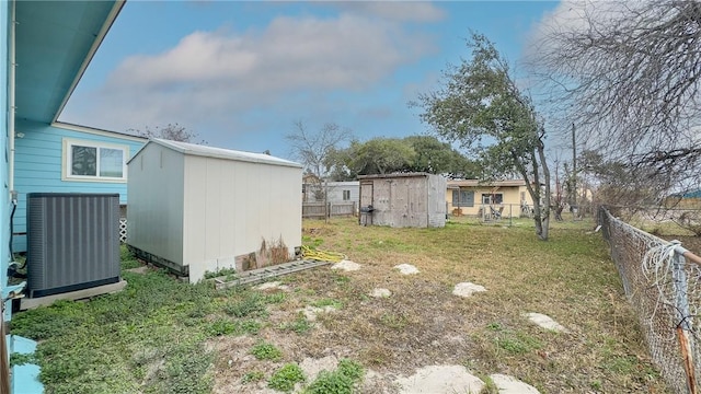 view of yard featuring central AC and a storage shed