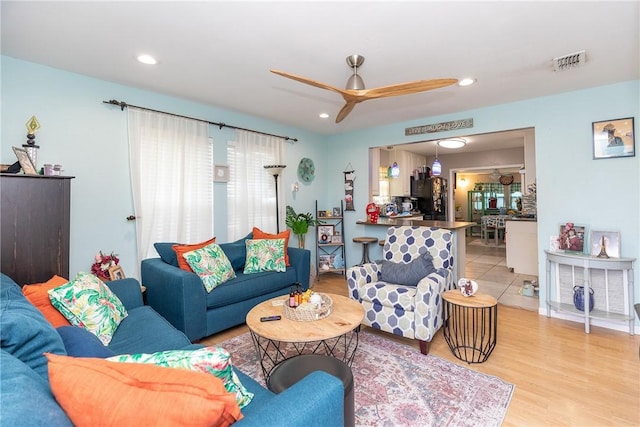 living room with ceiling fan and light hardwood / wood-style flooring