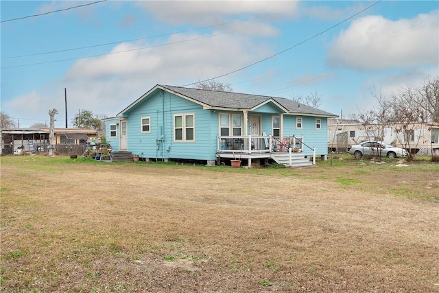 rear view of house featuring a yard