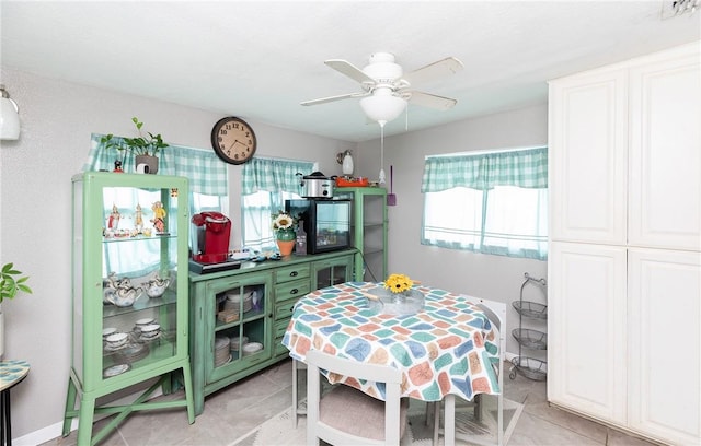 tiled dining room with a wealth of natural light and ceiling fan