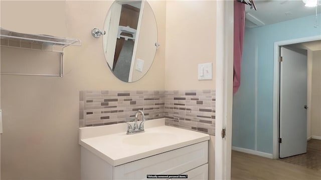 bathroom featuring vanity and backsplash