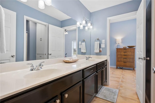 bathroom with ceiling fan, tile patterned flooring, a sink, and double vanity