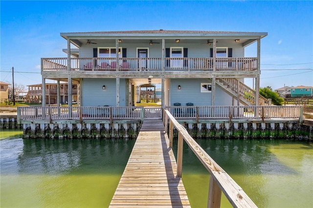 back of house with a ceiling fan and a water view